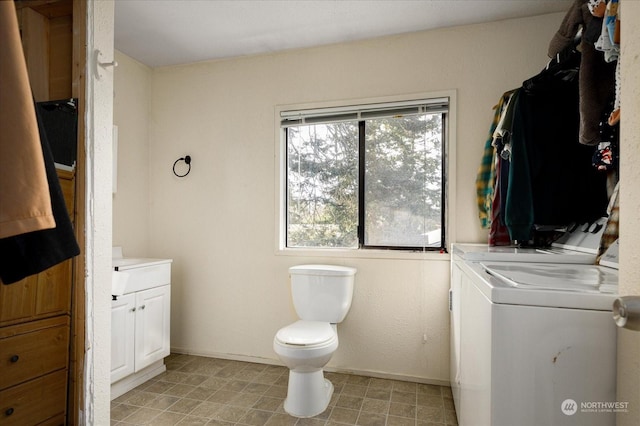 bathroom featuring toilet, vanity, and independent washer and dryer