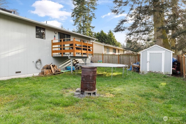 view of yard with a shed, a trampoline, and a wooden deck