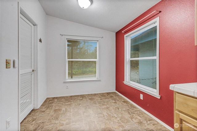 unfurnished room featuring lofted ceiling