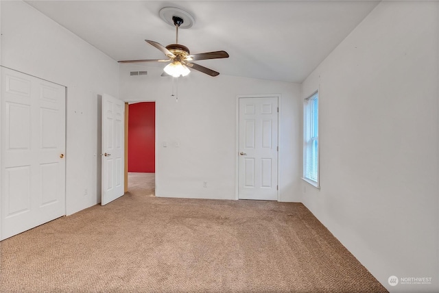 unfurnished bedroom featuring lofted ceiling, ceiling fan, and carpet