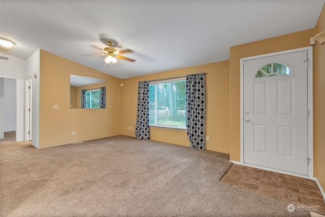 foyer with carpet flooring, ceiling fan, and vaulted ceiling