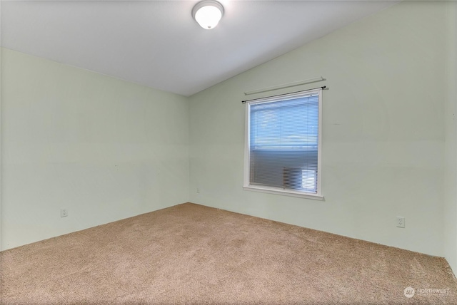 empty room with vaulted ceiling and carpet flooring