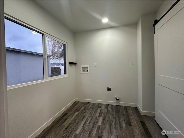 washroom featuring a barn door, dark hardwood / wood-style flooring, washer hookup, and hookup for an electric dryer