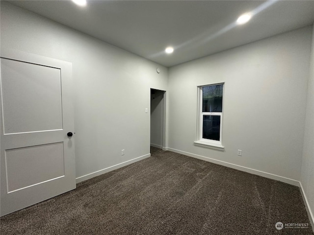 empty room featuring dark carpet