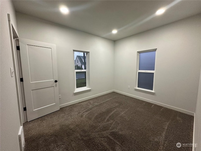 empty room featuring dark carpet