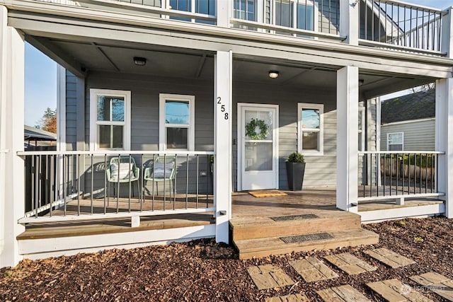 property entrance featuring a porch and a balcony