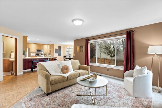 living room with light colored carpet and a notable chandelier