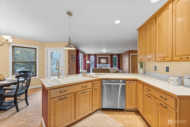 kitchen with kitchen peninsula, sink, pendant lighting, an inviting chandelier, and dishwasher