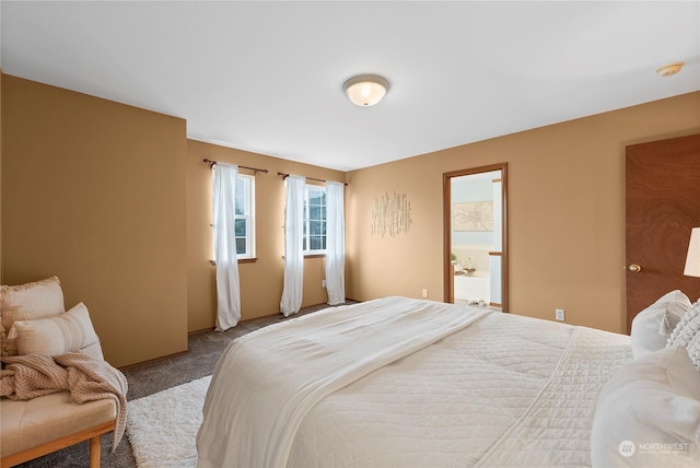 bedroom featuring ensuite bathroom and carpet floors