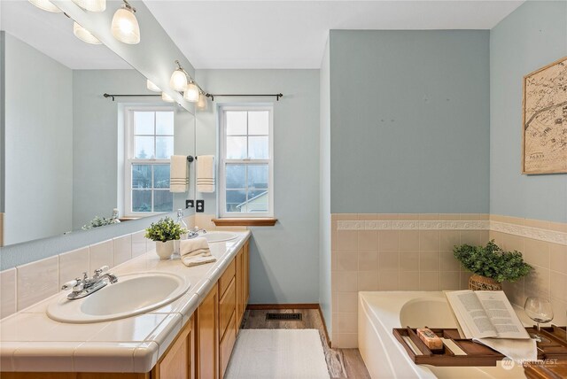 bathroom featuring hardwood / wood-style floors, vanity, and a bath