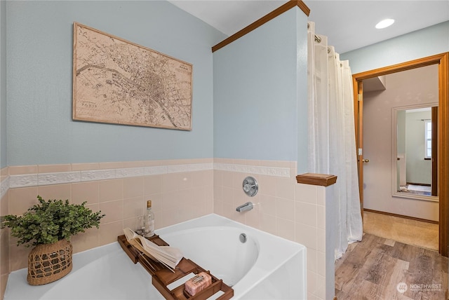 bathroom featuring a bathing tub, tile walls, and hardwood / wood-style flooring