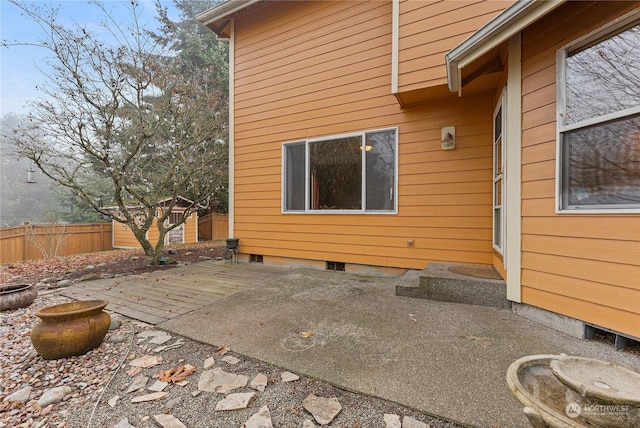 view of side of home featuring a patio and a storage shed