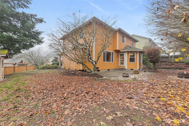 rear view of property with a fire pit and a patio area