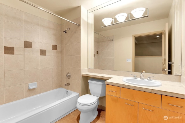 full bathroom with tile patterned flooring, vanity, tiled shower / bath combo, and toilet