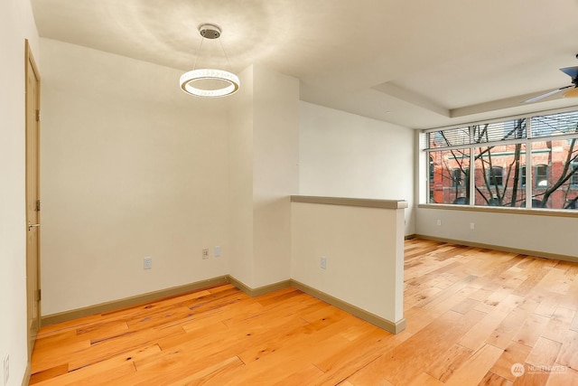 spare room with ceiling fan and light wood-type flooring