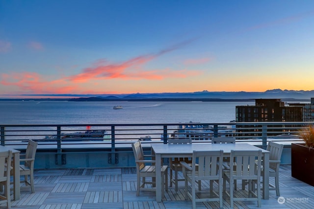 patio terrace at dusk with a balcony and a water and mountain view