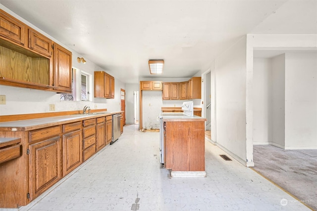 kitchen with dishwasher, stove, a kitchen island, and sink