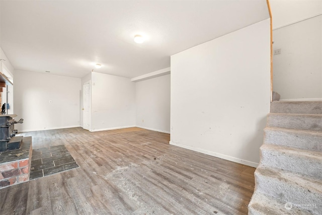 basement featuring hardwood / wood-style flooring and a wood stove