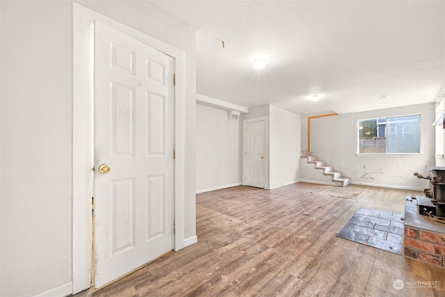 interior space featuring a wood stove, hardwood / wood-style floors, and a textured ceiling