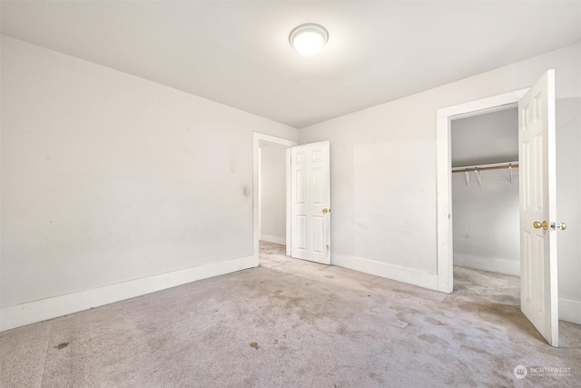 unfurnished bedroom featuring a closet and light colored carpet