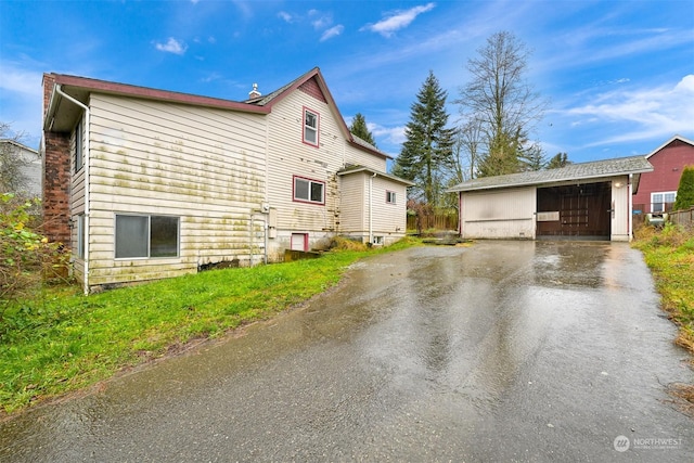 view of side of property featuring a garage and an outbuilding