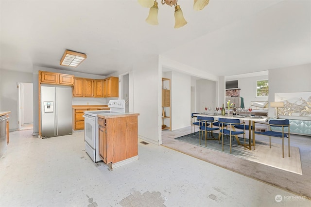 kitchen with stainless steel refrigerator with ice dispenser, white range with electric stovetop, and a kitchen island