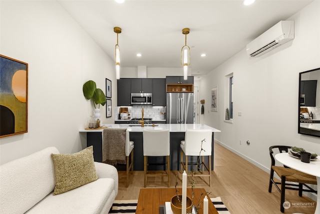 kitchen featuring tasteful backsplash, kitchen peninsula, decorative light fixtures, a breakfast bar, and appliances with stainless steel finishes