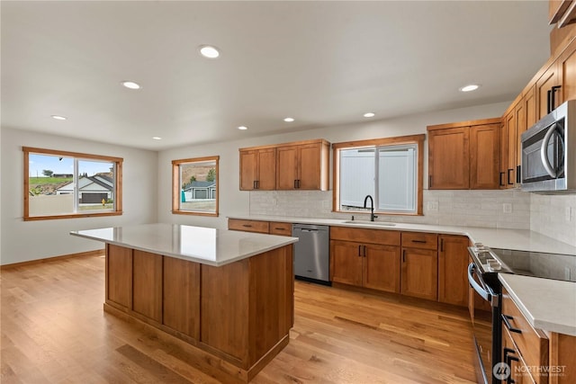 898 N Nile Ave, East Wenatchee, WA 98802 - kitchen with appliances with stainless steel finishes, a sink, brown cabinetry, decorative backsplash, and recessed lighting