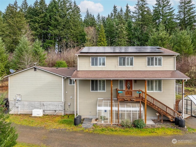 view of front of house featuring an outbuilding, solar panels, and a deck