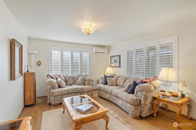 living room with a wall mounted AC, light hardwood / wood-style flooring, and a notable chandelier