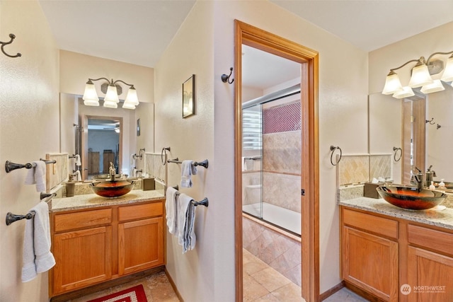 bathroom with an enclosed shower, vanity, and tile patterned floors