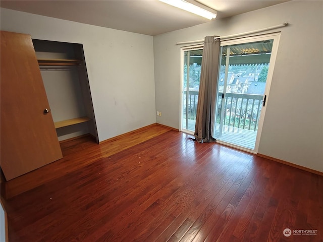 unfurnished bedroom featuring hardwood / wood-style flooring, access to outside, and a closet