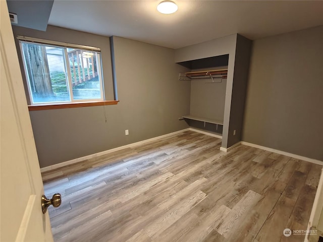 unfurnished bedroom with a closet and light wood-type flooring