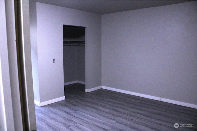 unfurnished bedroom featuring dark hardwood / wood-style flooring and a closet