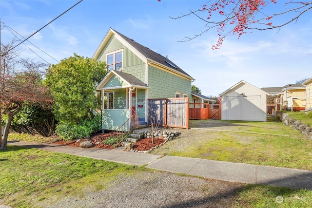 view of front of house with a front yard and a storage shed