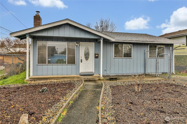 1675 S 57th St, Tacoma, WA 98408 - view of front of house with board and batten siding, a chimney, and a shingled roof