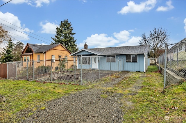 1675 S 57th St, Tacoma, WA 98408 - view of front of property with board and batten siding, a fenced backyard, and a chimney