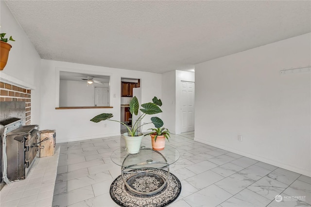 1675 S 57th St, Tacoma, WA 98408 - living area with light marble finish flooring, a textured ceiling, ceiling fan, and a fireplace
