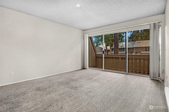 unfurnished room featuring carpet and a textured ceiling