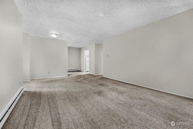 spare room with carpet flooring, a textured ceiling, and a baseboard heating unit