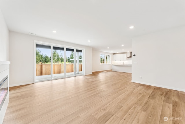 unfurnished living room featuring sink and light wood-type flooring