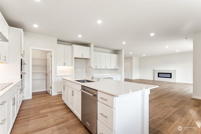 kitchen with white cabinetry, appliances with stainless steel finishes, a kitchen island with sink, and sink