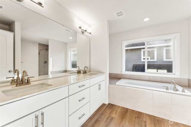 bathroom with independent shower and bath, vanity, and wood-type flooring