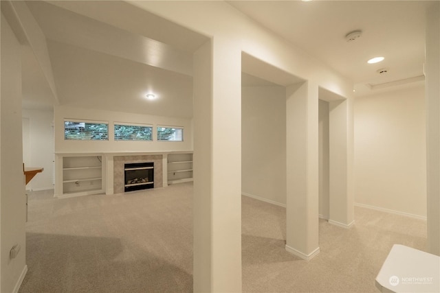 hall featuring built in shelves and light colored carpet