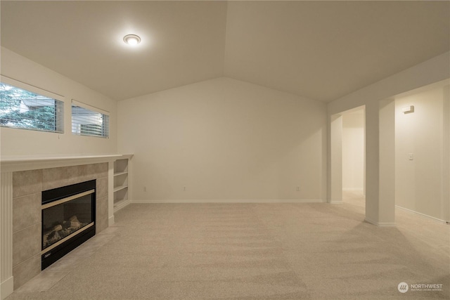 unfurnished living room featuring light colored carpet, a fireplace, and vaulted ceiling