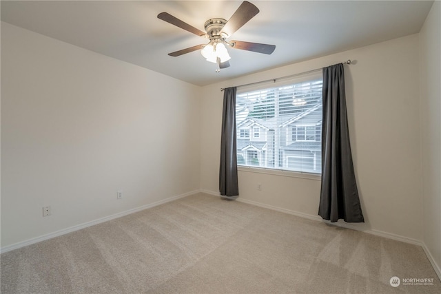 carpeted spare room with ceiling fan