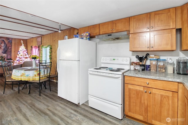 kitchen featuring white appliances, hardwood / wood-style flooring, and wood walls