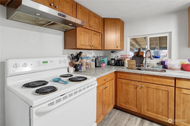 kitchen with electric range, sink, light stone counters, and light wood-type flooring