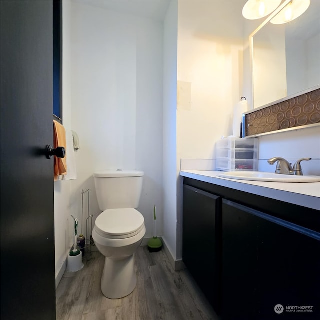 bathroom with hardwood / wood-style floors, vanity, and toilet