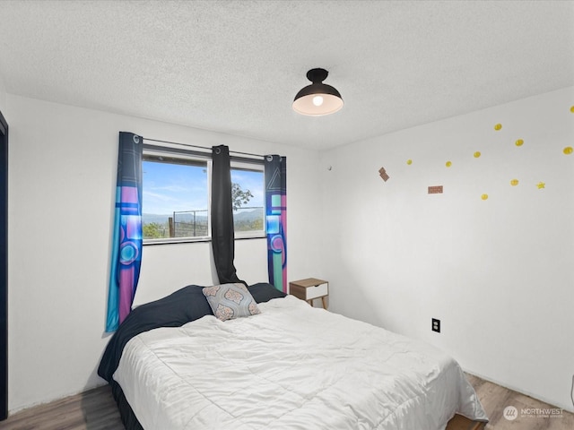 bedroom featuring a textured ceiling and hardwood / wood-style flooring